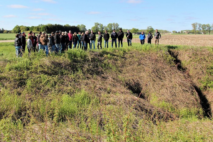 Davin Heinbuck, Water Resources Coordinator with Ausable Bayfield Conservation Authority, spoke on sinkholes, buffers, and two-stage ditches during a bus tour of almost 50 drainage engineers and drainage superintendents.