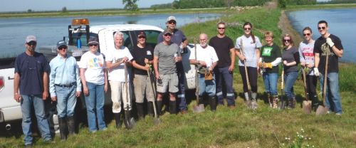 Volunteers pose after planting wetland plants, shrubs and trees at the Forest sewage lagoons