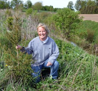 Joanne Scott says planting trees attracts birds, reduces erosion, and keeps her farm cool in the summer.